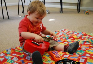 Toddler explores ukulele